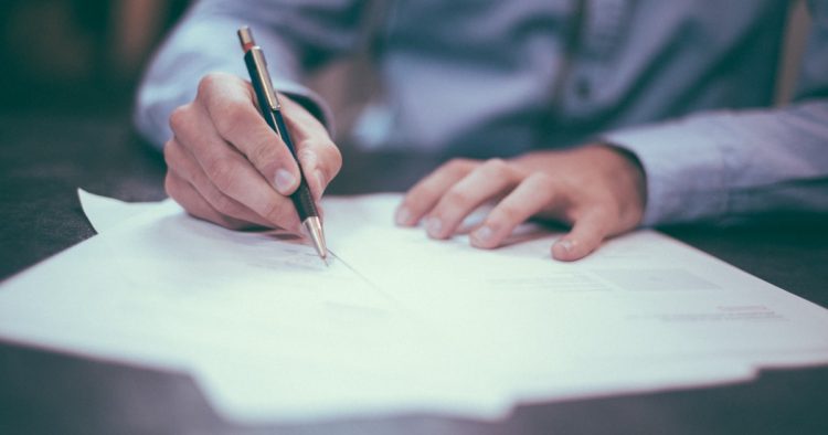 學生在書桌前填寫申請文件，代表 SAT、ACT、TOEFL 官方成績單的送分流程